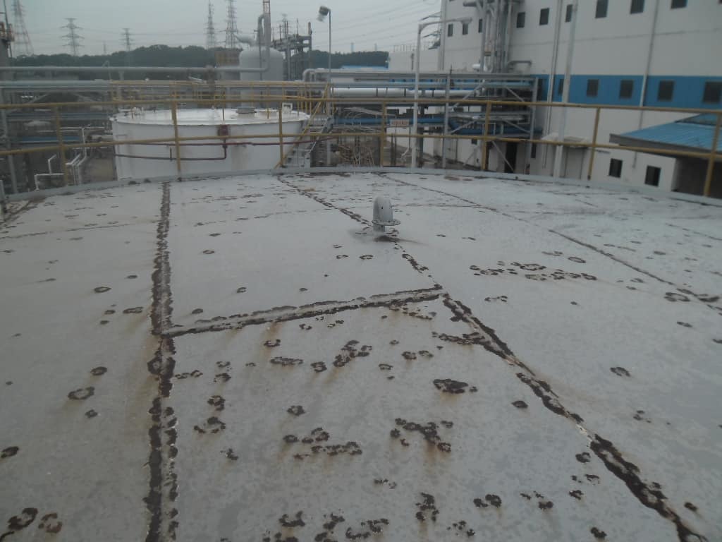 unpainted crude oil tank roof with rusted yellow railing