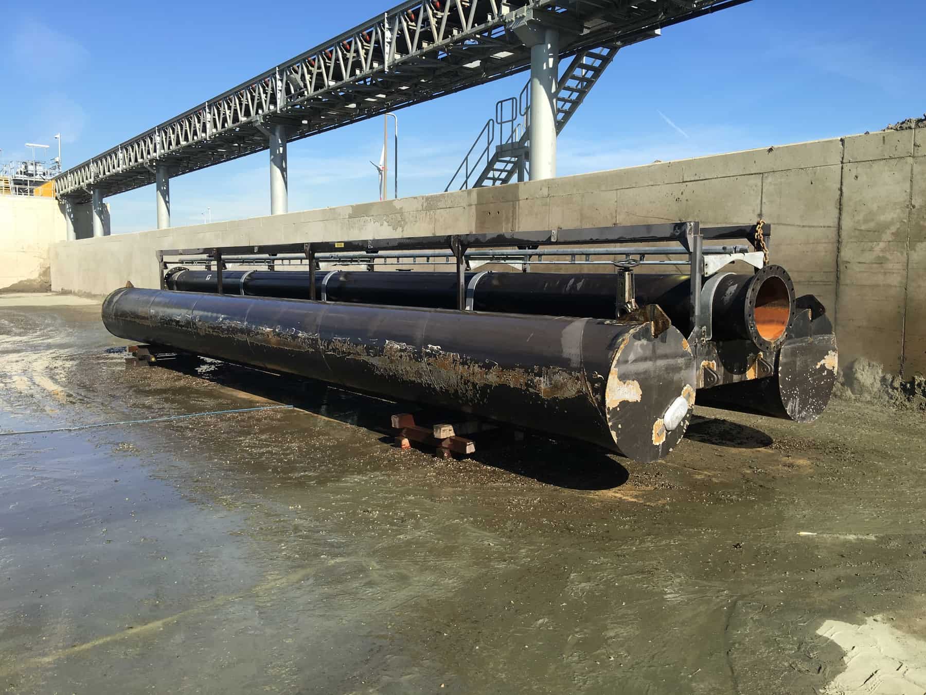 Before Application rusted black pipes with failed paint on dock