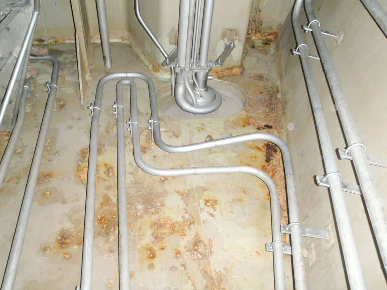 blistered chemical tank floor with grey piping
