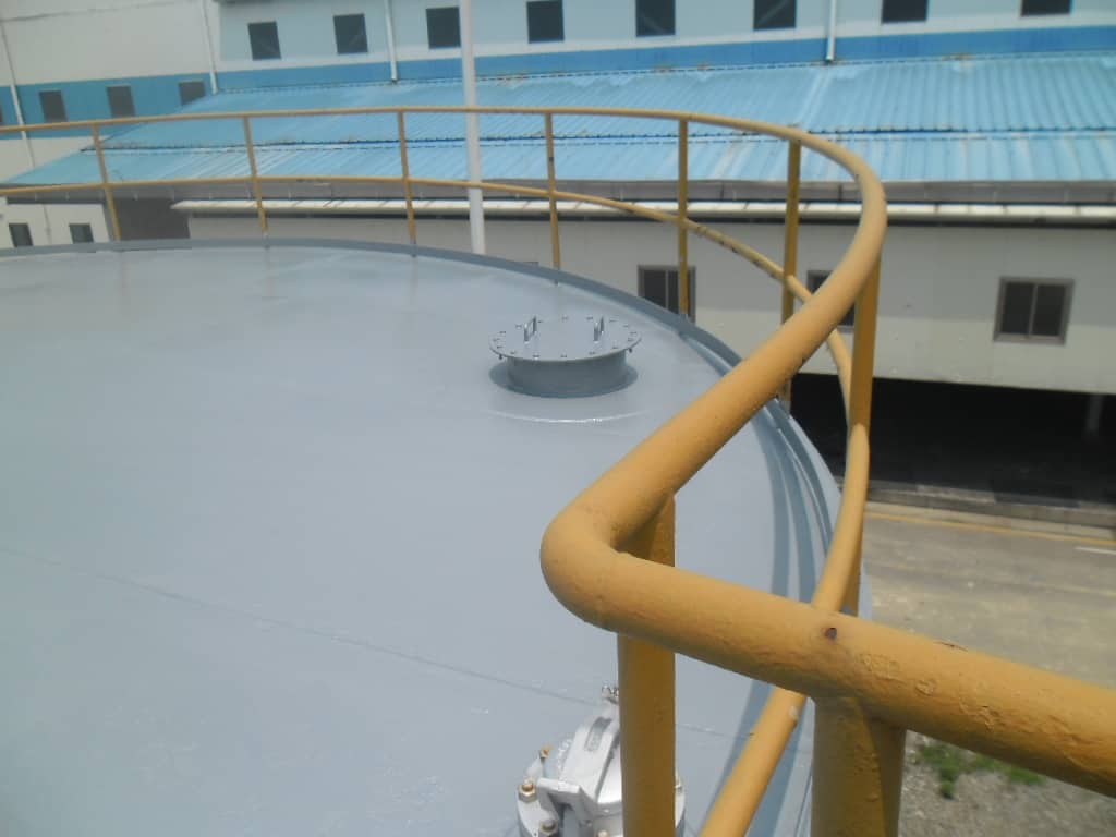 crude oil tank roof painted in grey with yellow railing