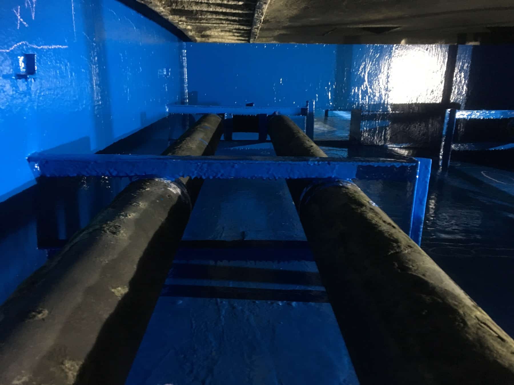 process tank painted in blue with two large unpainted pipes