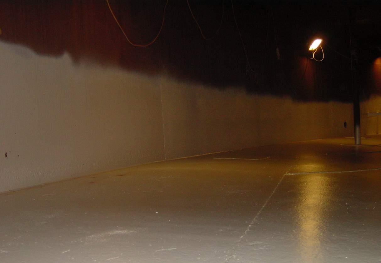 dimly lit chemical tank internal partially painted in white