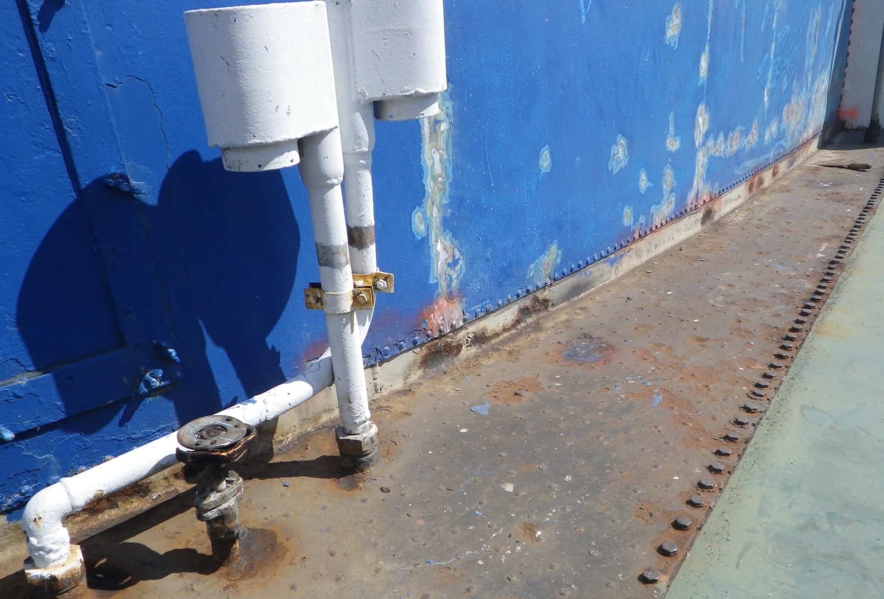 blistered blue funnel wall and ship decking/pipes