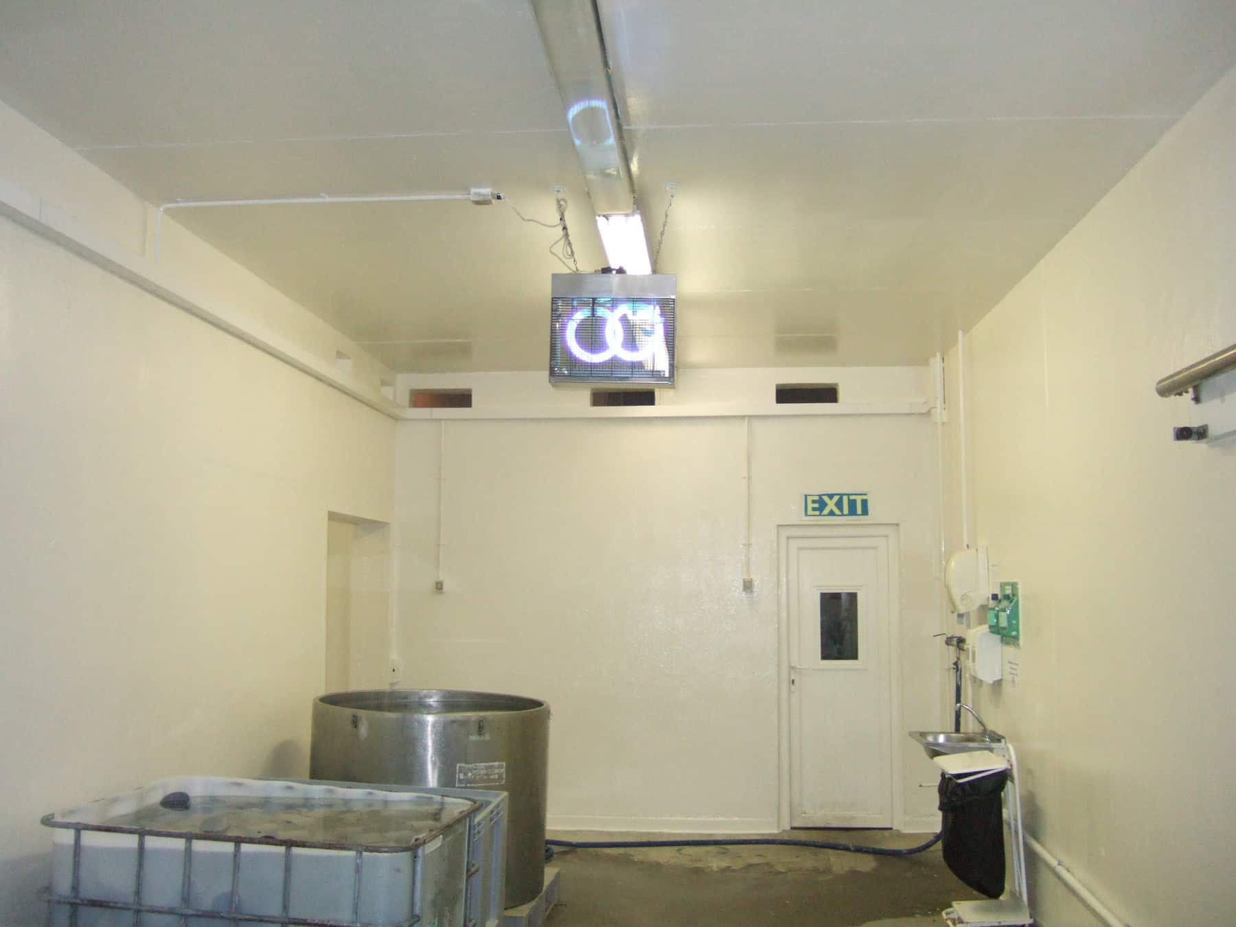 square manufacturing room painted in white with metal containers